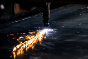 A welder cutting a piece of metal with sparks